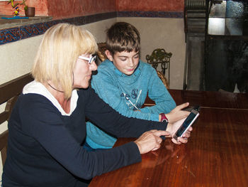Grandmother and grandson using mobile phones at home