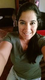 Portrait of smiling young woman sitting at home