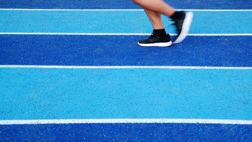 Low section of people walking on running track