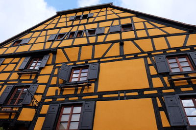 Low angle view of yellow building against sky