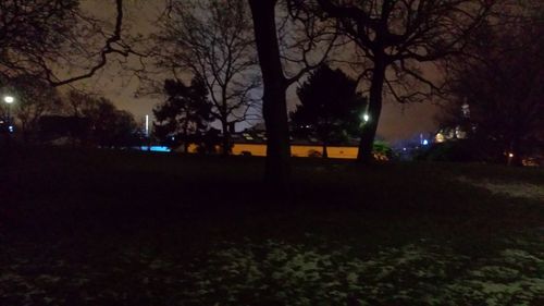 Illuminated street light against sky at night