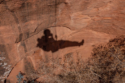 Full frame view of the shadow of a rock climber against a sandstone cliff