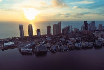 Aerial view of buildings in city during sunset