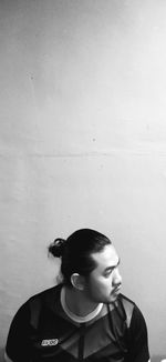 Full length of a boy looking away against wall