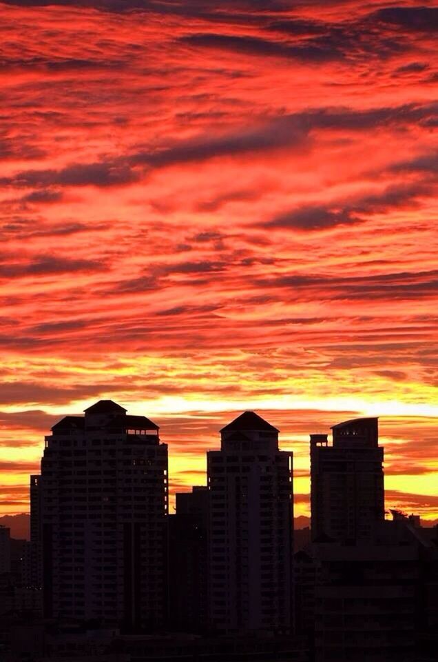 sunset, orange color, architecture, building exterior, built structure, sky, city, silhouette, cloud - sky, dramatic sky, building, low angle view, beauty in nature, skyscraper, cloud, outdoors, no people, romantic sky, nature, scenics