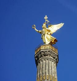 Low angle view of statue of liberty against blue sky