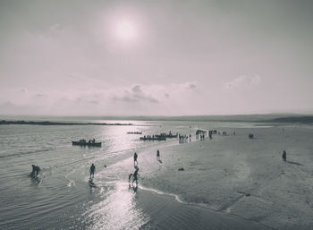 People on beach against sky