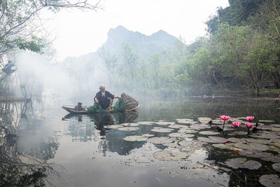 Rear view of man walking on lake