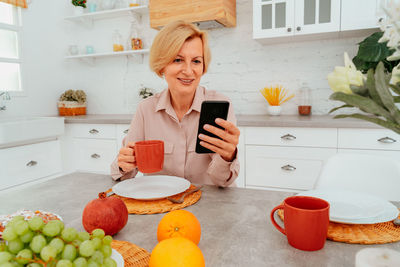 Young woman using phone on table