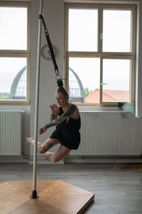 Side view of young woman exercising in gym