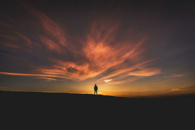 Silhouette of man standing at sunset