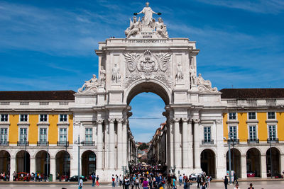 People at rua augusta arch against sky