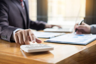 Midsection of man using mobile phone