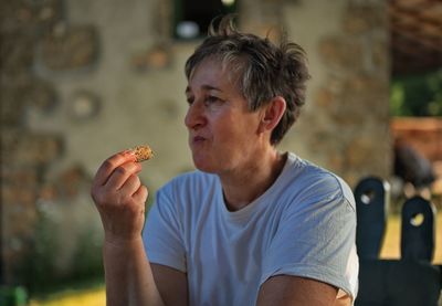 Portrait of mature woman holding homemade cookie
