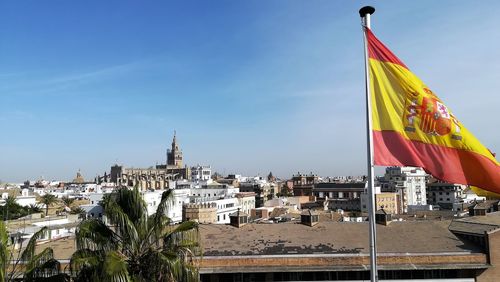 Low angle view of flags in city against sky