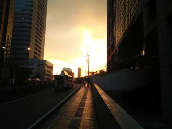 Modern city against sky during sunset