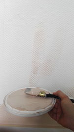 Close-up of hand holding coffee cup on table