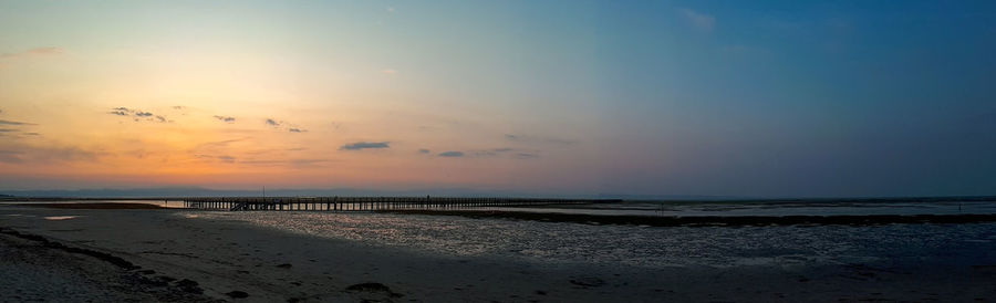 Scenic view of beach against sky during sunset