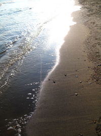 Close-up of wave on beach against sky during sunset