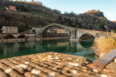 Arch bridge over river against sky