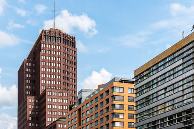 Low angle view of buildings against cloudy sky