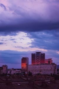 Buildings in city against sky at sunset