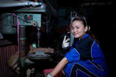 Portrait of young woman standing in factory