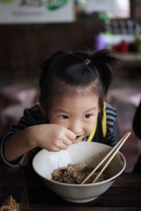 Close-up of girl eating noodles at home