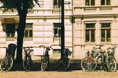 Bicycles parked on street against building in city