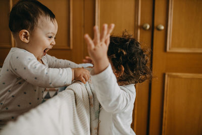 Side view of cute brother and sister at home