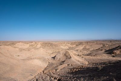 Scenic view of desert against clear blue sky