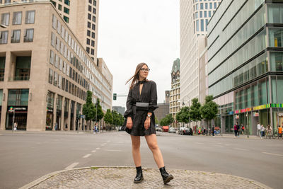 Full length portrait of woman on city street