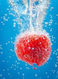 Close-up of water drops on glass against blue background