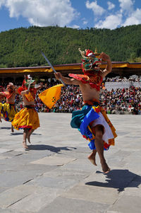 Rear view of people dancing against sky