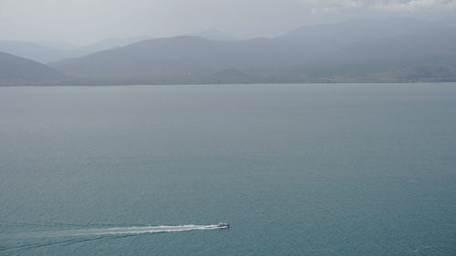 Scenic view of sea and mountains against sky