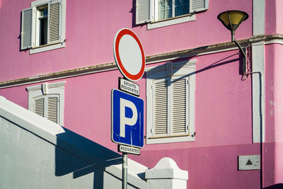 Low angle view of road sign against building