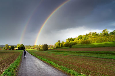 Scenic view of rainbow over field against sky