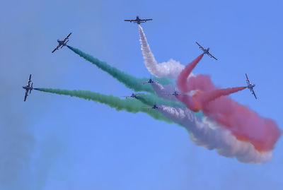 Low angle view of airshow against sky