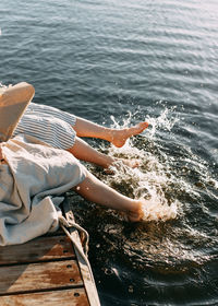 Girls sit on the beach playing and splashing their feet in the water