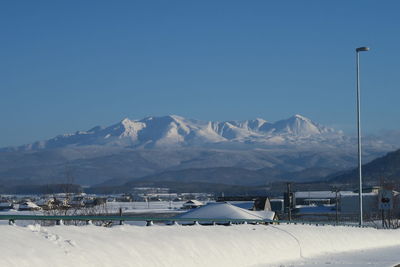 Scenic view of snowcapped mountains against clear blue sky