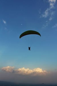 Low angle view of parachute against cloudy sky