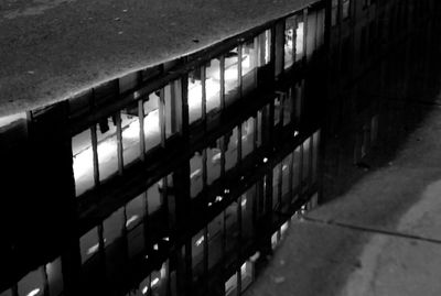 High angle view of illuminated footpath by building at night