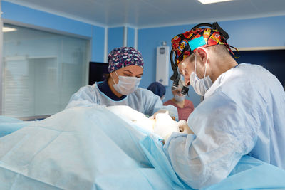 Midsection of female doctor examining patient in hospital