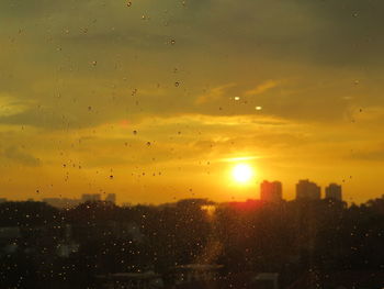 View of city through window during sunset