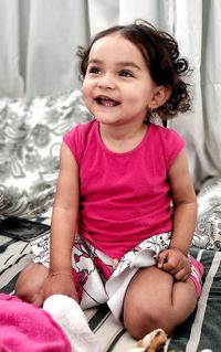 Cute girl sitting on bed at home