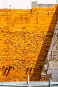 Low angle view of yellow wall by building