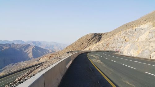 Road by mountain against clear sky