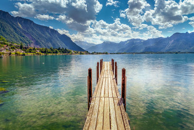 Wooden pier over lake against sky