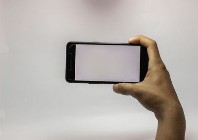 Low angle view of hand holding mobile phone