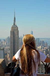 Woman on skyscraper looking at cityscape